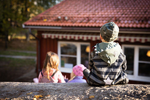 Ett barn sitter på ett berg precis intill förskolan Björkbacken.