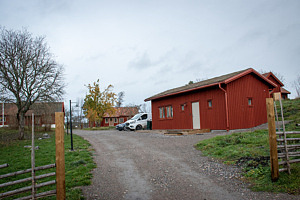 Röd stuga som ramas in av grindstolpar.