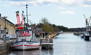 Vy ut från hamnbassängen med en båt i förgrunden och den nya fiskebryggan i bakgrunden