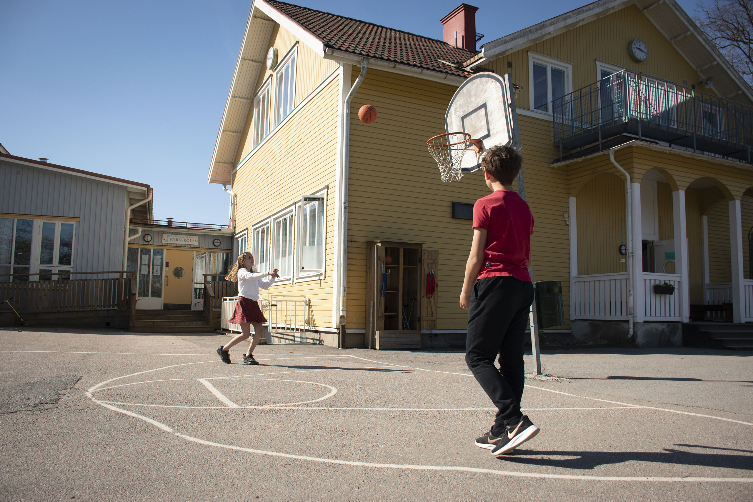 Sigrid och Sasha spelar basket på skolgården.