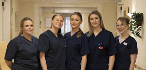 5 kvinnor står bredvid varandra iklädda arbetskläder för vård och omsorg.