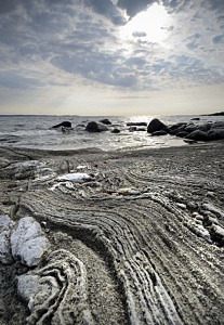 Vy över stenhäll på Persö med hav i horisonten.