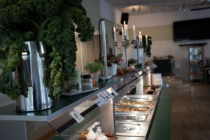 Matsalen i Kyrkskolan är höstpyntad med levande ljus, höstlöv och grönkålsbuketter.