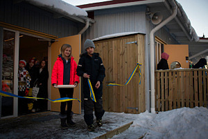Två elever står vid ingången till de nya lokalerna på Kyrkskolan och klipper det symboliska bandet under invigningsceremonin.