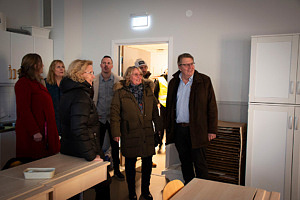 På bild står sex personer i en klunga och tittar på det nya klassrummet.