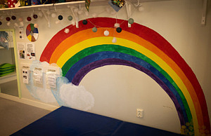 Inomhus, en regnbåge målad på väggen, en hylla