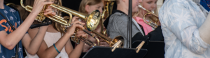 Närbild på händer som håller i instrument, trumpeter.