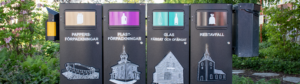 Avfallskärl på rad i en park.