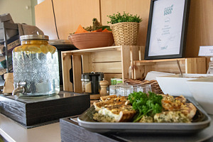 Ett fat med paj, en behållare med vatten, hyllor med pumpor och växter.